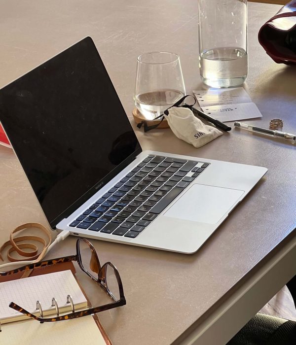 Retreat planner working on itinerary details with laptop and notes